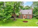 Charming brick home featuring a well-manicured lawn and classic architectural details at 6220 E 56Th St, Indianapolis, IN 46226