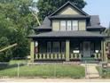Charming two-story home featuring a covered front porch and a well-maintained yard at 624 N Rural St, Indianapolis, IN 46201
