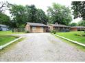 Single-story home with a gravel driveway and a detached garage at 6601 Twin Brooks Dr, Indianapolis, IN 46227