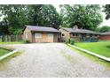 Single-story home with a gravel driveway and a detached garage at 6601 Twin Brooks Dr, Indianapolis, IN 46227
