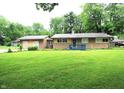 Charming single-story home with a well-manicured lawn and a cozy blue front porch at 6601 Twin Brooks Dr, Indianapolis, IN 46227