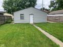 View of the backyard with a detached garage and a neatly maintained lawn at 730 N Riley Ave, Indianapolis, IN 46201