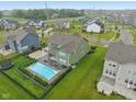 View of the backyard featuring a swimming pool with a patio area in a lush green lawn at 8165 Oakley Ter, Zionsville, IN 46077
