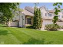 View of townhome with a well-maintained lawn and mature trees at 9406 Avon Strand # Apt A, Avon, IN 46123
