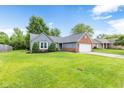 Attractive home with green lawn, beautiful landscaping, brick, and two-car garage at 11218 Baycreek Dr, Indianapolis, IN 46236