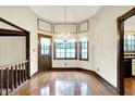 Elegant dining area showcasing gleaming hardwood floors, a stylish chandelier, and ample natural light at 116 Bennington Rd, Indianapolis, IN 46227