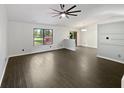 Open-concept living area with wood-look flooring, large windows, and access to the dining space at 11722 Hartland Dr, Indianapolis, IN 46229