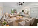 Comfortable living room with a large window, ceiling fan, and modern decor, flowing into the dining area at 11722 Hartland Dr, Indianapolis, IN 46229