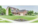 Lovely two-story home with lush green lawn, mature trees, and blooming flower beds at 12679 Chargers Ct, Fishers, IN 46037