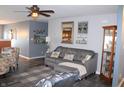 Comfortable living room featuring a gray sofa, stylish decor, and a ceiling fan for added comfort at 12901 N Collett Way, Camby, IN 46113