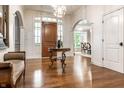 Elegant foyer with hardwood floors, decorative table, and arched doorway views the dining room at 13346 W Sherbern Dr, Carmel, IN 46032
