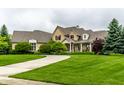 Elegant home with manicured front lawn and covered porch, perfect for outdoor enjoyment at 13346 W Sherbern Dr, Carmel, IN 46032