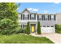 Charming two-story home with a well-manicured lawn, mature trees, and a welcoming yellow front door at 13844 N Cardonia Dr, Camby, IN 46113
