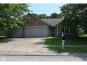 Charming single-story home features a brick facade, attached garage, and well-maintained lawn at 1411 Mimosa Ct, Greenfield, IN 46140