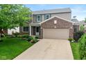 Charming two-story home with a well-manicured lawn, brick accents and attached two-car garage at 14446 Chapelwood Ln, Fishers, IN 46037