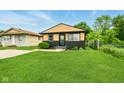 Charming single Gathering home with manicured lawn, neutral paint scheme and welcome wreath on the front door at 1513 S Rural St, Indianapolis, IN 46203