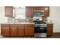 Modern kitchen featuring stainless steel appliances, granite countertops, and dark wood cabinets offering ample storage space at 1513 S Rural St, Indianapolis, IN 46203