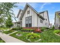 Stylish two-story home featuring manicured lawn, brick accents, and colorful flowerbeds at 1586 Mairn Ave, Carmel, IN 46032