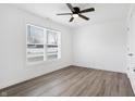 Bright bedroom with a ceiling fan, large window, and stylish gray wood flooring at 1612 Paula Dr, Columbus, IN 47201