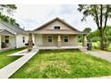 Attractive single-story home featuring a covered front porch, small yard and neat landscaping, enhancing its curb appeal at 2026 Spruce St, Indianapolis, IN 46203