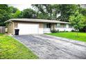 Home with a large driveway, attached garage, and well-kept lawn showcasing the exterior at 22 Brooklyn Ct, Mooresville, IN 46158