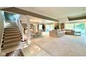 Open-concept living room with staircase, dining area, and sliders to the backyard at 2213 E Canterbury Ct, Martinsville, IN 46151