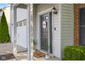 Charming front door with a 'Welcome' sign, sidelight window, and cozy, covered porch at 2247 Rolling Hill Ct, Columbus, IN 47201