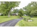 Wide driveway leading to a charming home with mature trees and a well-maintained lawn at 2457 N Centerline Rd, Franklin, IN 46131