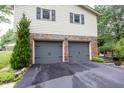 Attached two-car garage with gray doors, brick accents, and a well-maintained asphalt driveway at 2457 N Centerline Rd, Franklin, IN 46131