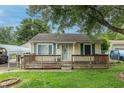 Lovely home with yellow siding, green shutters, and a charming front porch and covered carport at 2620 13Th St, Columbus, IN 47201