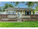 Inviting one-story home featuring a front porch, yellow siding, green shutters, and well-maintained lawn at 2620 13Th St, Columbus, IN 47201