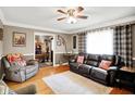 Cozy living room features hardwood floors, a ceiling fan, and comfortable leather seating at 2907 Jay Dee Ln, Greenwood, IN 46143