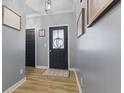 Inviting entryway featuring hardwood floors, neutral paint, and a stylish front door at 3599 Chalmers Dr, Bargersville, IN 46106