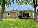 Well-manicured front lawn featuring a brick home with covered porch and American flag at 419 N 14Th Ave, Beech Grove, IN 46107