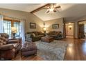 Cozy living room featuring high ceilings, ceiling fan, hardwood floors, and comfortable seating at 421 Kingsway Ct, Mooresville, IN 46158