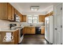 Functional kitchen equipped with wood cabinets, modern appliances, and durable flooring at 5303 Windridge Dr # 172, Indianapolis, IN 46226