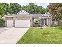 Inviting single-story brick home featuring a three-car garage and manicured lawn at 545 Pitney Dr, Noblesville, IN 46062