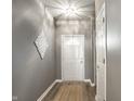 Clean entryway featuring a white front door, stylish wall decor, and modern flooring at 5883 Hollow Oak, Carmel, IN 46033