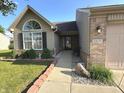 Inviting single-story home with manicured landscaping, featuring a brick and vinyl exterior at 6027 Crystal View Dr, Indianapolis, IN 46237