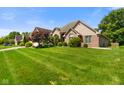 Attractive brick home with a sprawling green lawn, mature trees, and well-maintained landscaping at 648 Shakespeare Dr, Avon, IN 46123