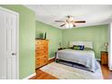 Comfortable bedroom with hardwood floors, a ceiling fan, and a queen-sized bed, creating a cozy retreat at 7600 S Oak Dr, Indianapolis, IN 46227