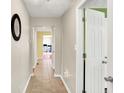 Inviting hallway featuring neutral walls, ceramic tile floors, and doors leading to other rooms of the house at 7600 S Oak Dr, Indianapolis, IN 46227