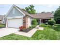 Beautiful ranch style home showcasing a two-car garage, brick accents, and mature landscaping at 7686 Micawber Ct, Indianapolis, IN 46256