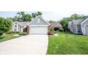 Charming single-story home featuring a manicured lawn, brick accents, and a convenient two-car garage at 7686 Micawber Ct, Indianapolis, IN 46256