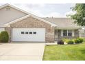 Attached two-car garage and brick exterior on a sunny day at 7687 Sea Crest N Way, Noblesville, IN 46062