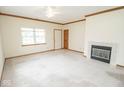 Spacious living room with neutral carpet, fireplace and ceiling fan at 7687 Sea Crest N Way, Noblesville, IN 46062
