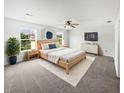 Serene main bedroom with neutral tones, ceiling fan, and ample natural light from large windows at 8437 Crosser Dr, Indianapolis, IN 46237