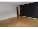 Spacious living room with laminate flooring and a contrasting black accent wall at 8609 Stonewall Dr, Indianapolis, IN 46231