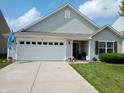 Charming single-Gathering home featuring a two-car garage, well-manicured lawn, and lush landscaping at 878 Sommersweet Run, Greenwood, IN 46143