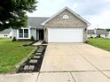 Lovely single-story home with a well-manicured lawn, brick details, and an attached two-car garage at 883 Halyard Dr, Avon, IN 46123